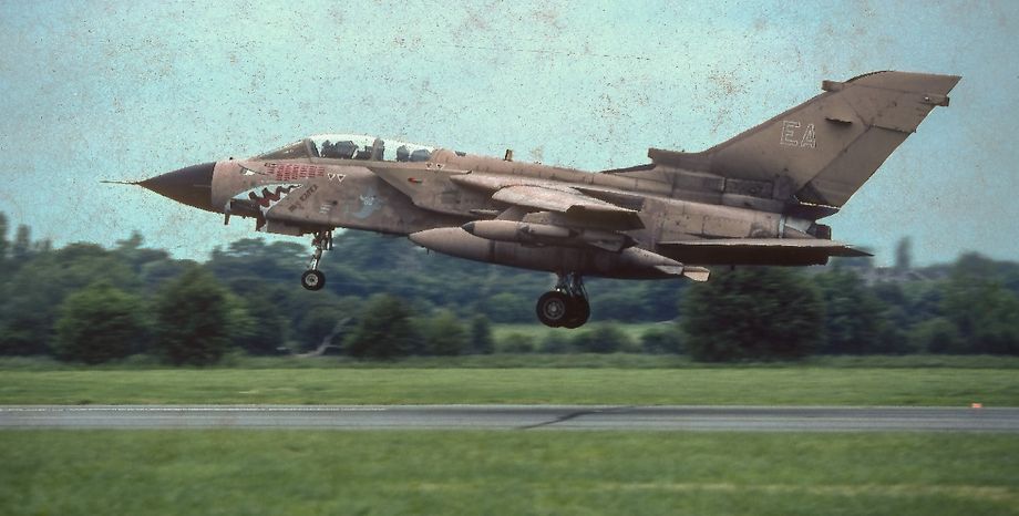 Tornado GR1 ZA447 ‘EA’ named “Mig Eater” departs Woodford in June 1991.  This aircraft destroyed a landing MiG29 while discharging the contents of its JP233 pod over an Iraqi air base.  Although this slide has a bad case of ‘celluloid fungus’ we thought it worth including.  Photo © D. Draycott.